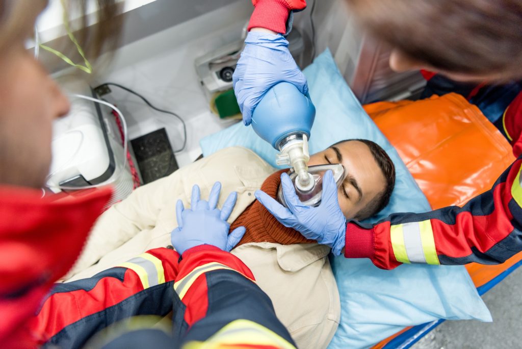 Paramedics doing cardiopulmonary resuscitation in ambulance car